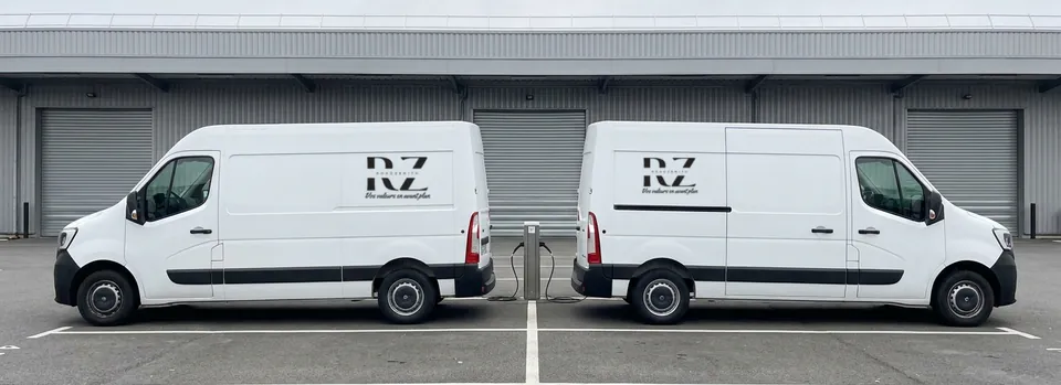 Deux fourgons électriques RZ Transport au dépôt, de part et d'autre d'une borne de recharge